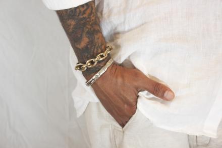 Mans hand in his pocket showing two bracelets