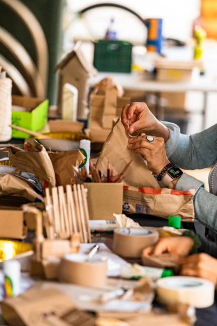 hands creating houses out of cardboard