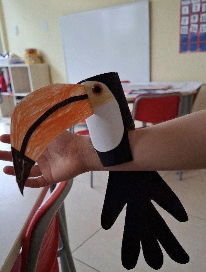 Paper toucan sitting on an arm
