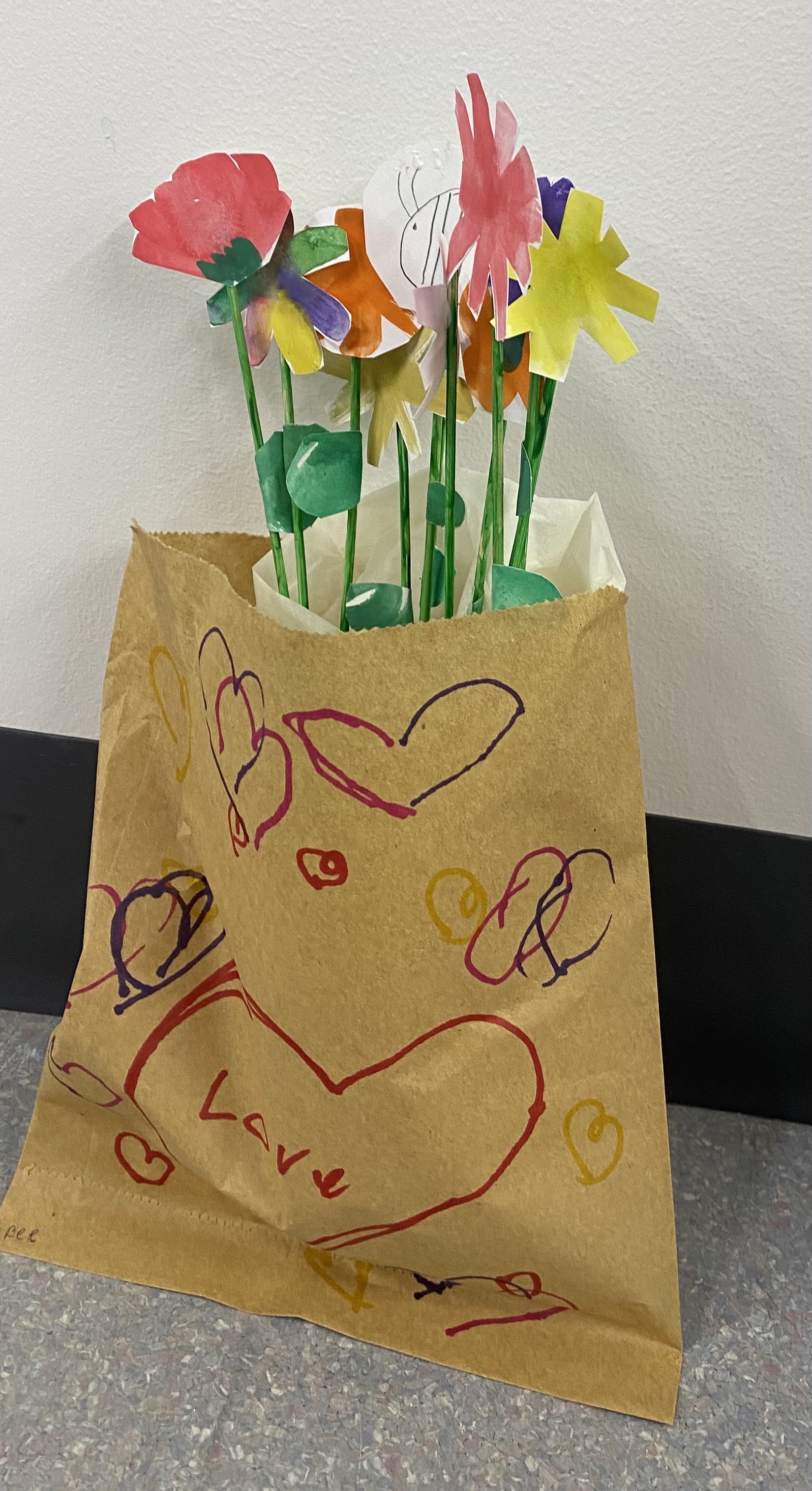 Watercolour flowers cut out and placed in a bag with drawn hearts