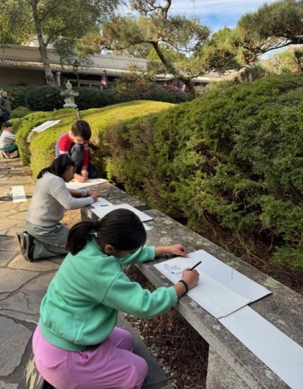 Children drawing on paper in the Japanese Gardens.