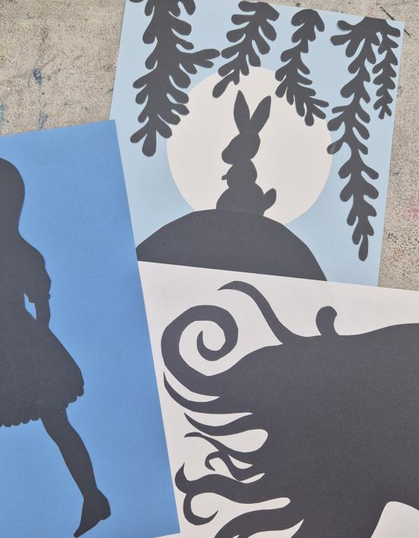 Black silhouettes of a girl, a side profile with flowing hair & a rabbit.