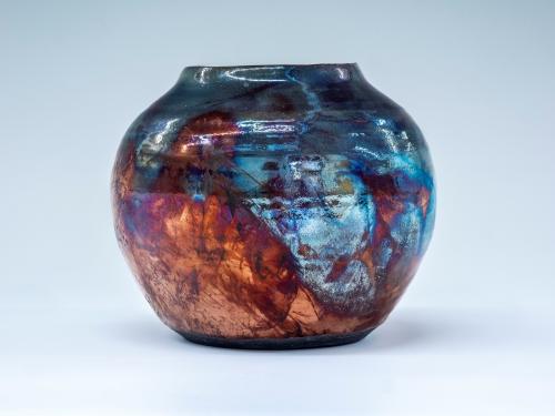 Photo of a ceramic vase with unusual colouring in shades of blue and red ochre